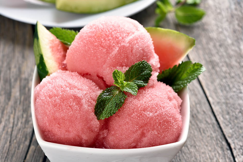 Scoops of watermelon sorbet in bowl, close up view