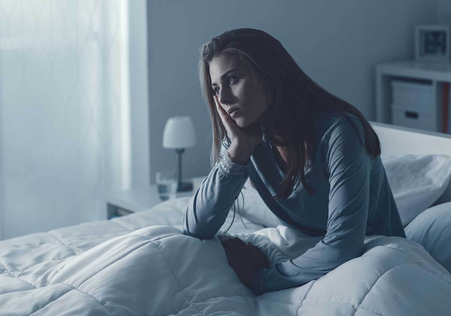 Depressed woman awake in the night, she is exhausted and suffering from insomnia