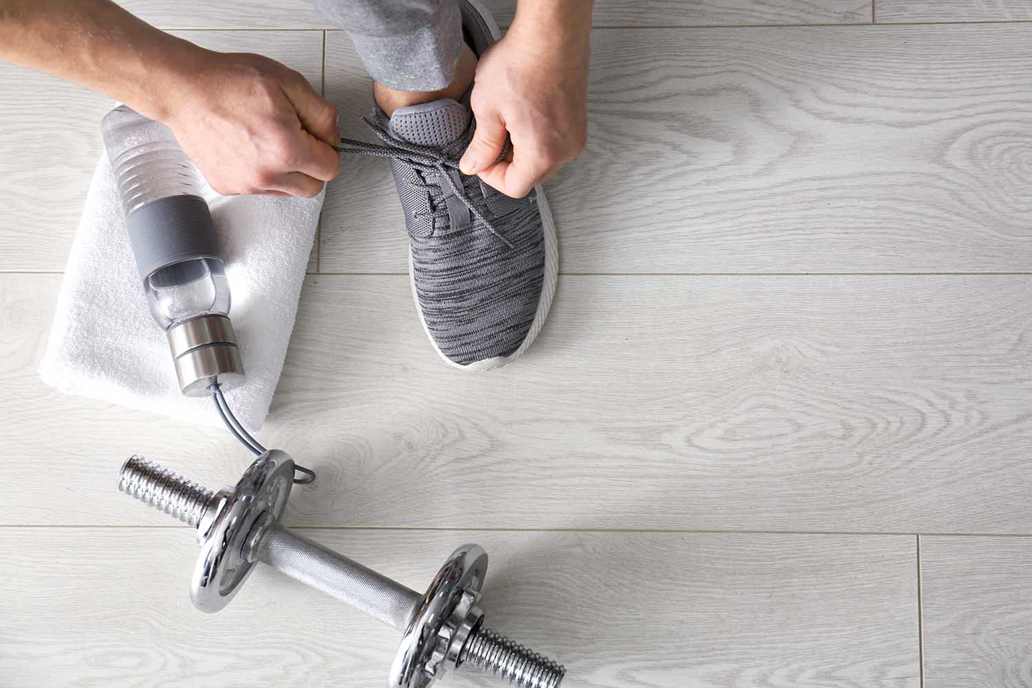 Man tying shoe laces in gym, top view