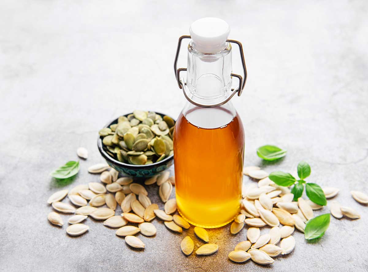 Bottle with pumpkin seed oil on gray concrete background