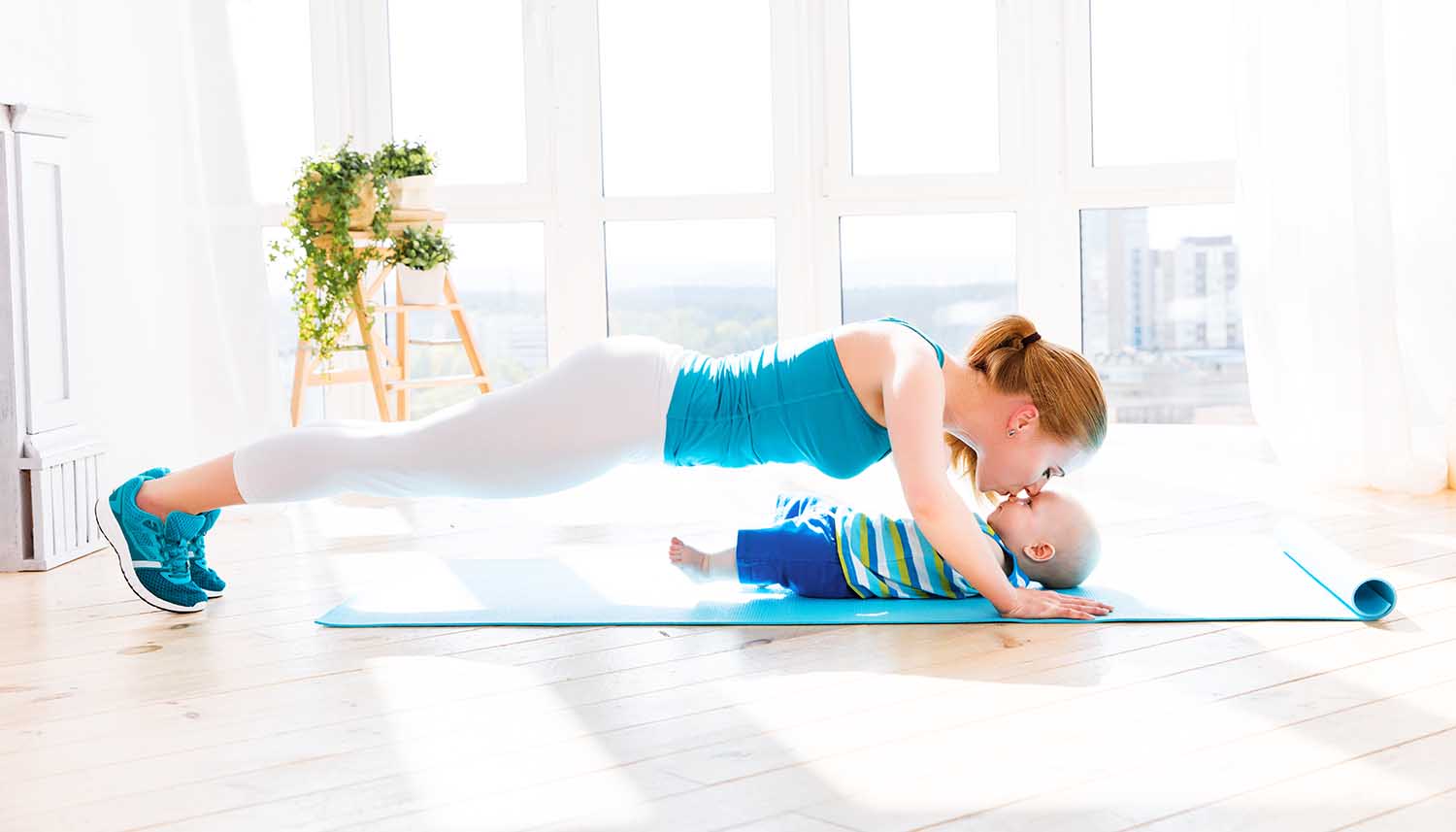 sports mother is engaged in fitness and yoga with a baby at home