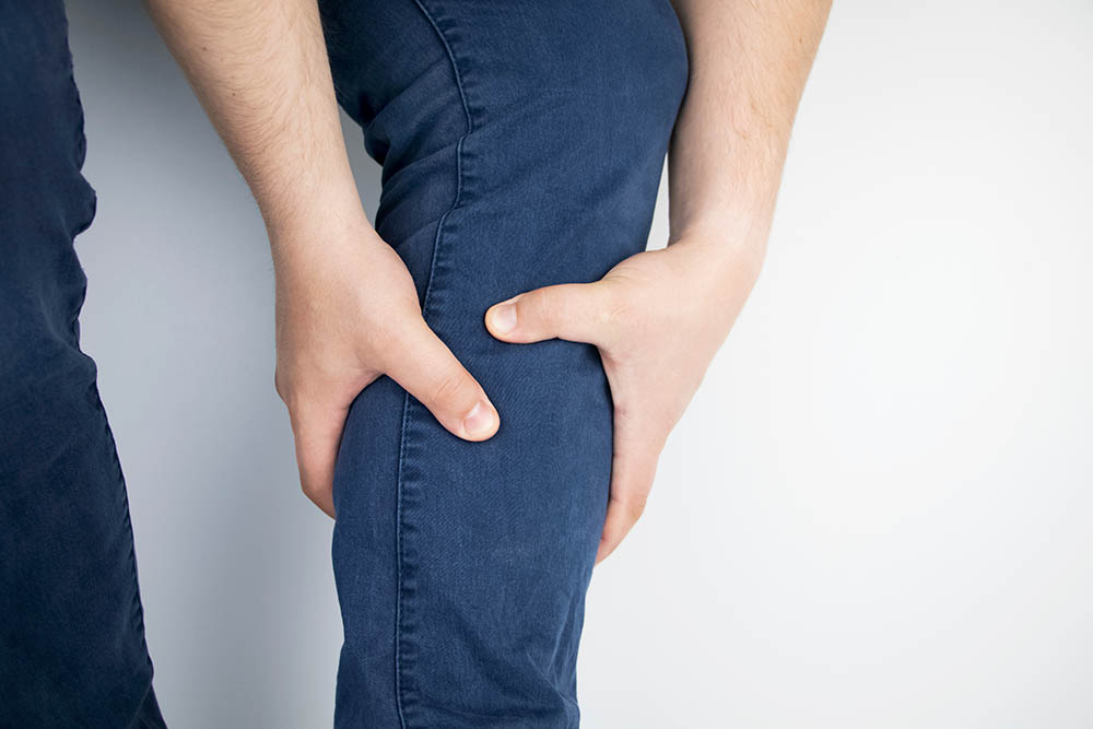 A man suffers from pain in the calves. Stretching the calf muscle, varicose veins, leg cramps, or myositis. Orthopedic doctor examines