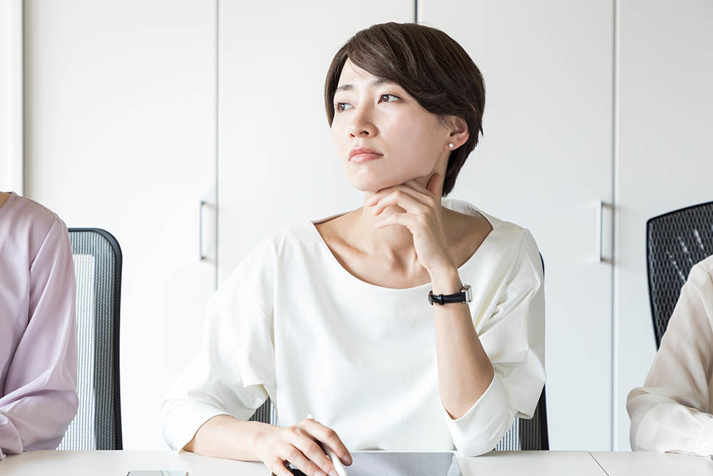 Thinking young woman in the office.