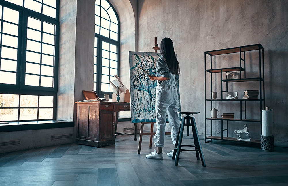 Beautiful asian female painter in art studio. Young talanted artist working.