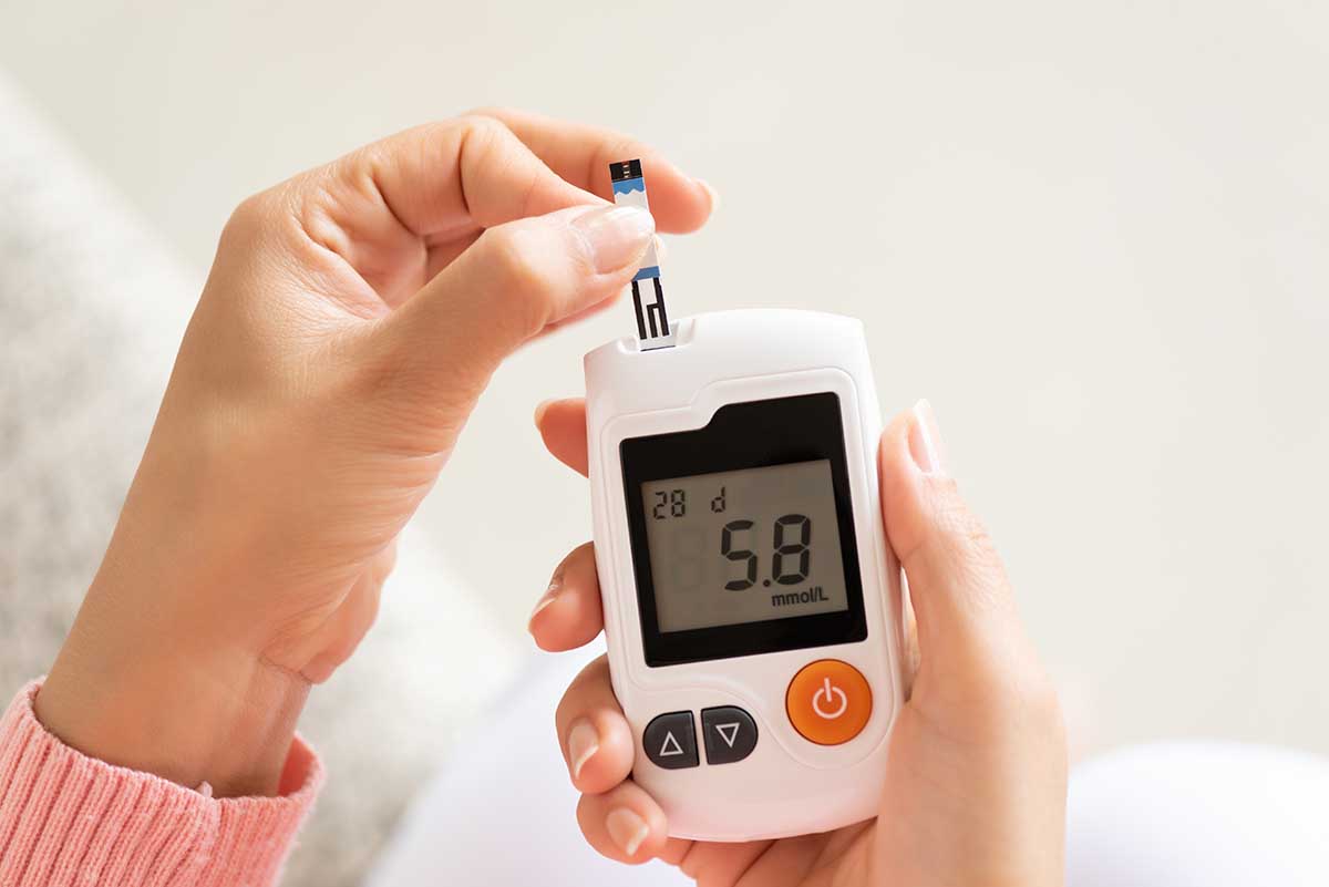 Close up of woman hands checking blood sugar level by Glucose meter for diabetes tester using as Medicine, glycemia, healthcare and medical concept.