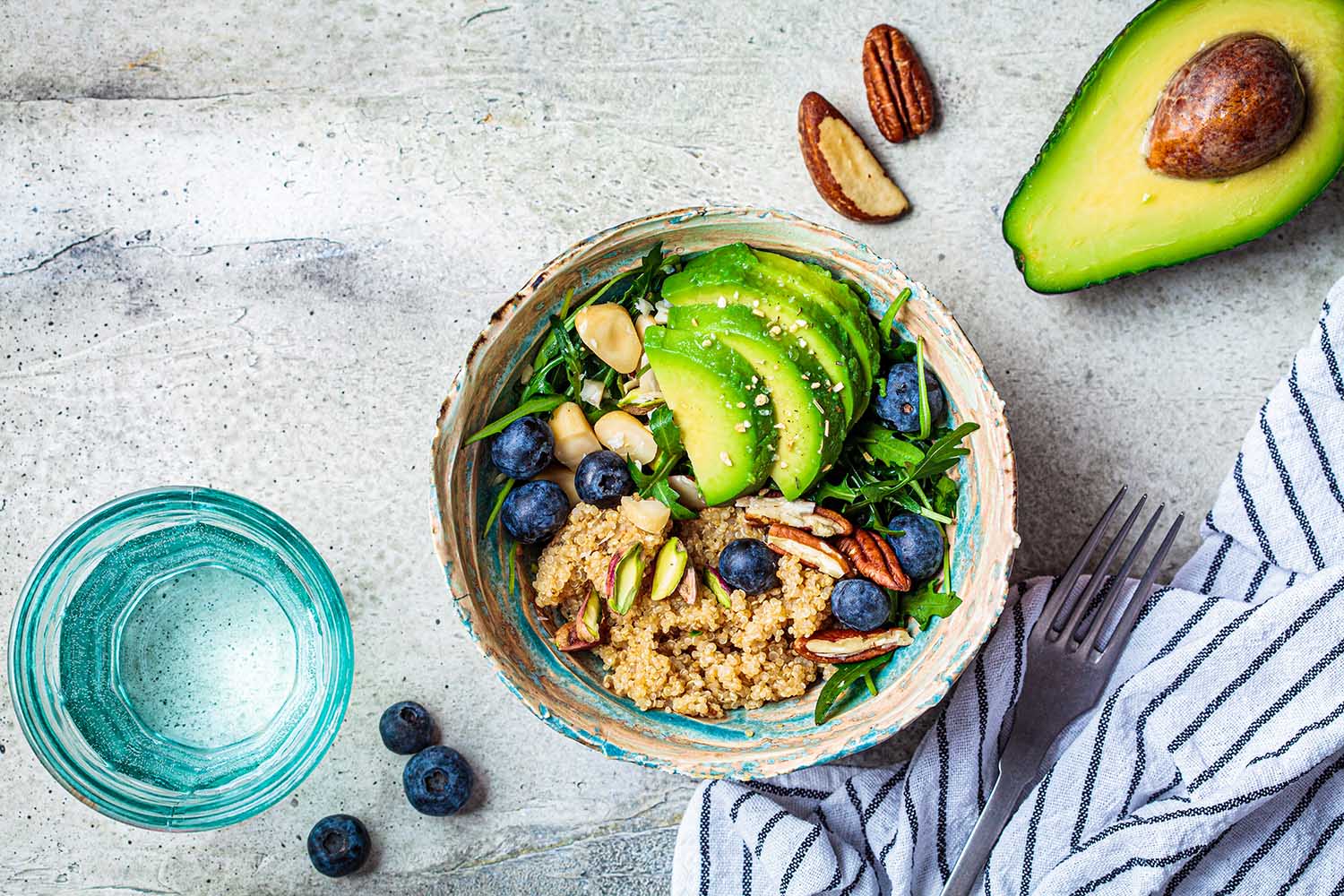 Vegan quinoa salad with berries, avocado and nuts. Healthy vegan food.