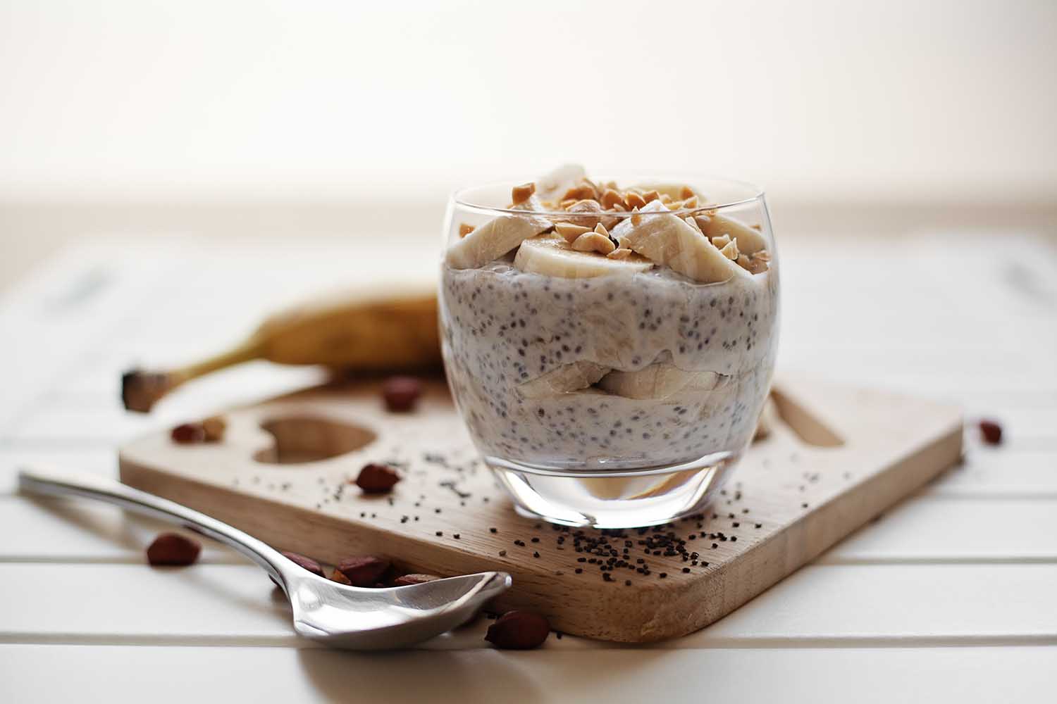 Banana chia yogurt pudding decorated with ripe sliced banana and peanuts