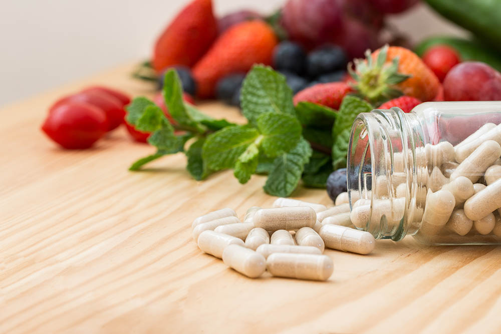 Vitamins supplements in bottle on wooden table.