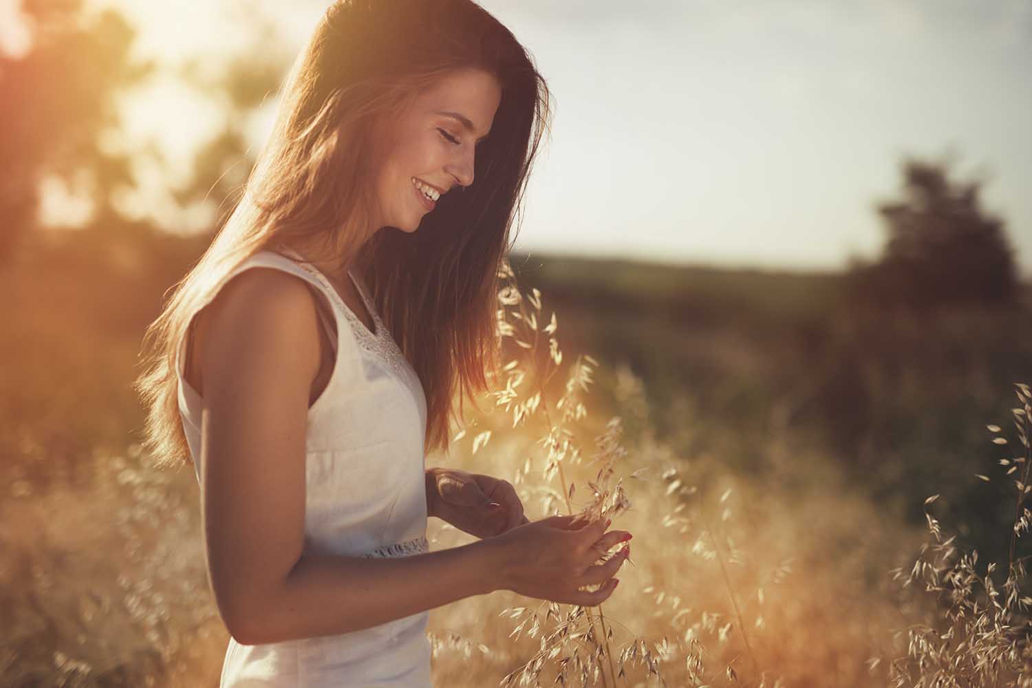Beautiful carefree woman in fields being happy outdoors