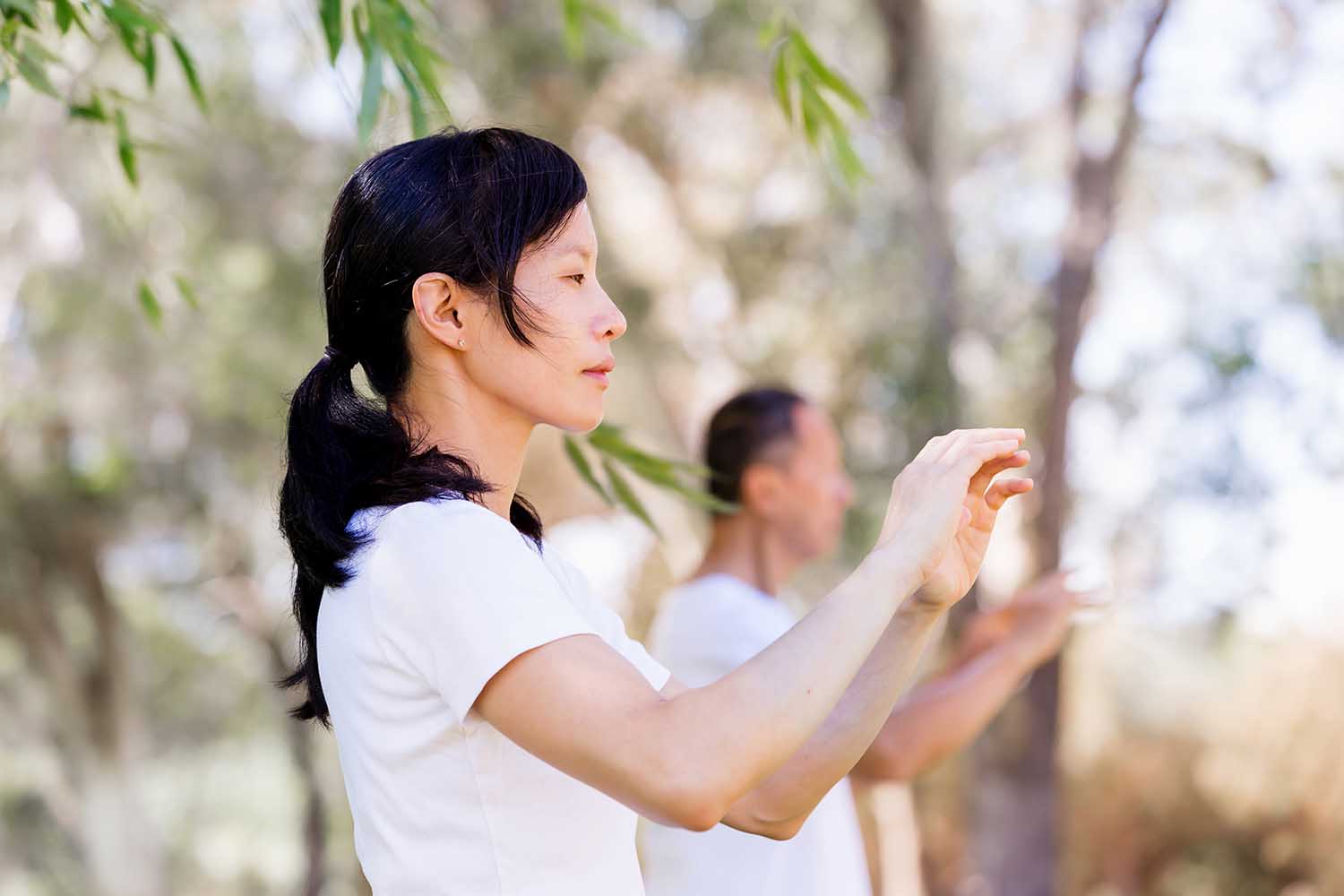 People practicing thai chi in park