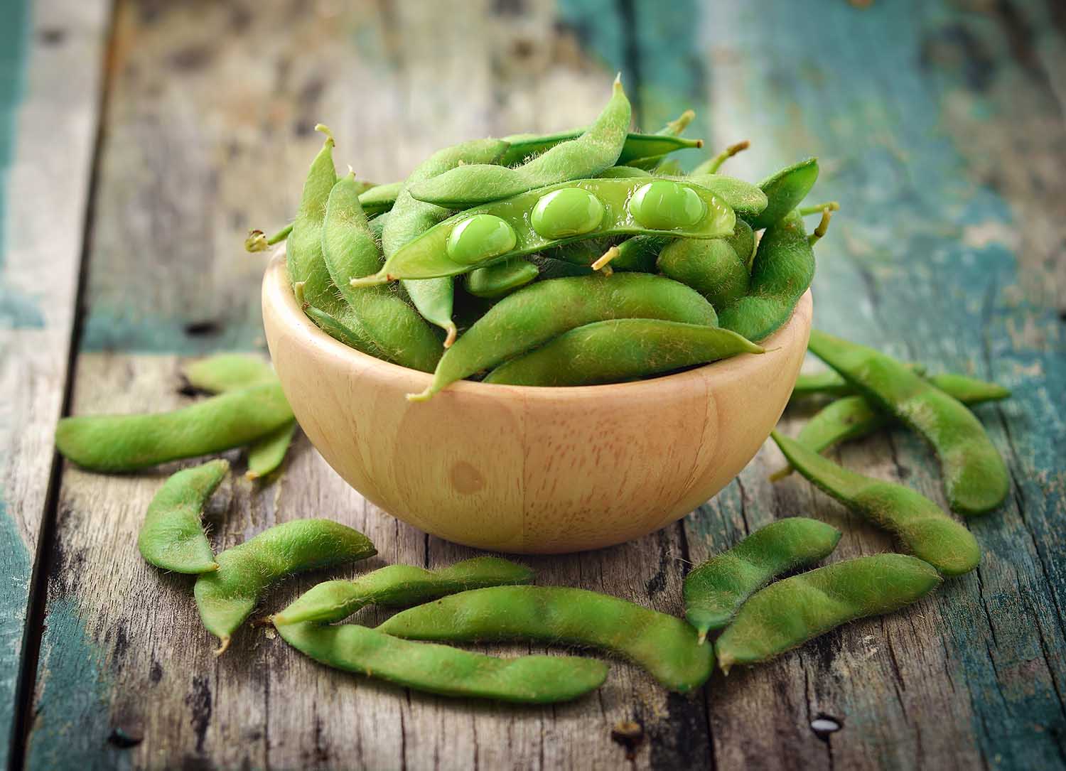 green soy beans in the wood bowl on table
