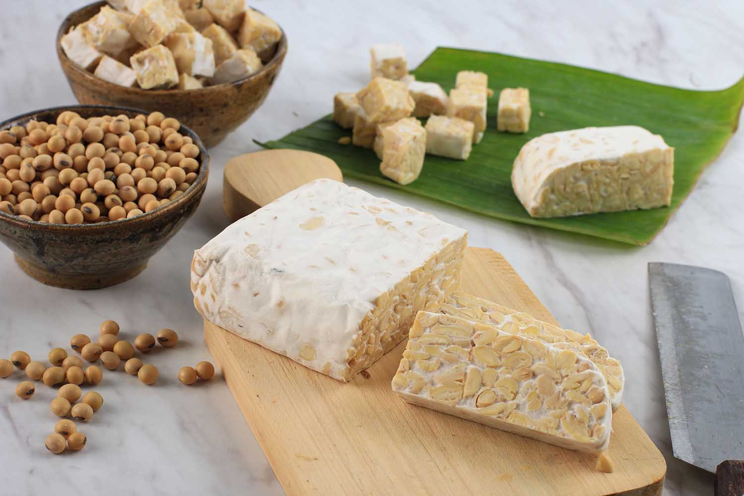 Raw Tempeh or Tempe. Tempeh Slices on Wooden Background, Cut by Asian Female Chef. Tempe Made From Fermented Soybeans. Copy Space for Text. Concept of Soy Product