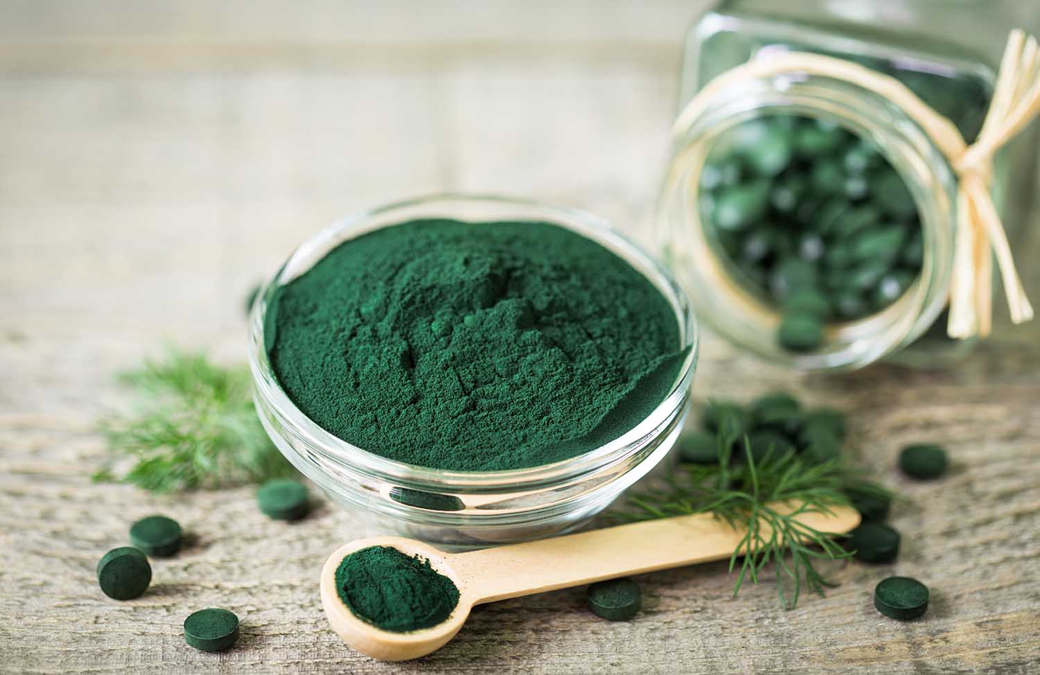 Spirulina powder and tablets in the bowl