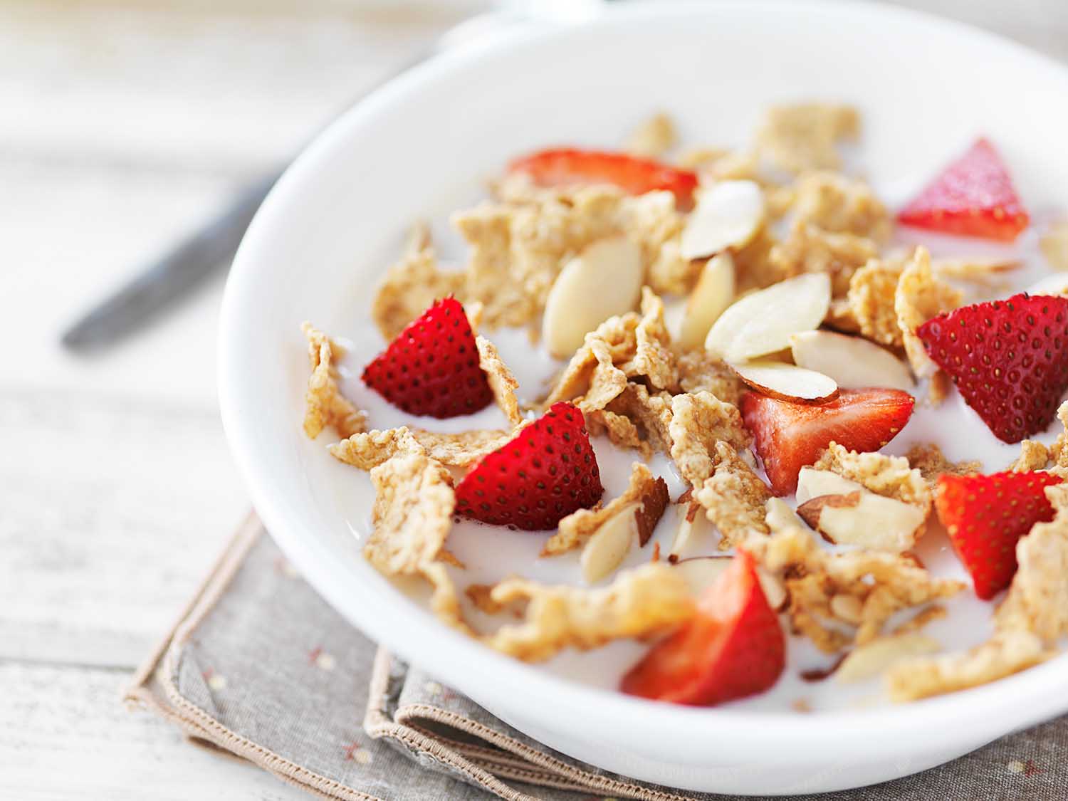 bowl of cereal with strawberries and almonds