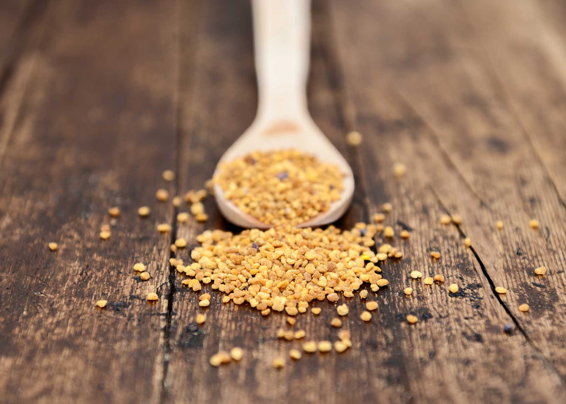 spoon with seeds isolated on pollen focus on rustic background