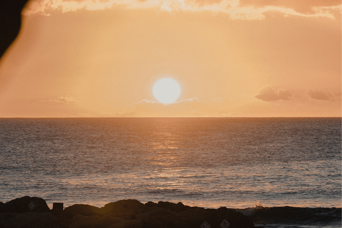 sunset at beach with water and rocks