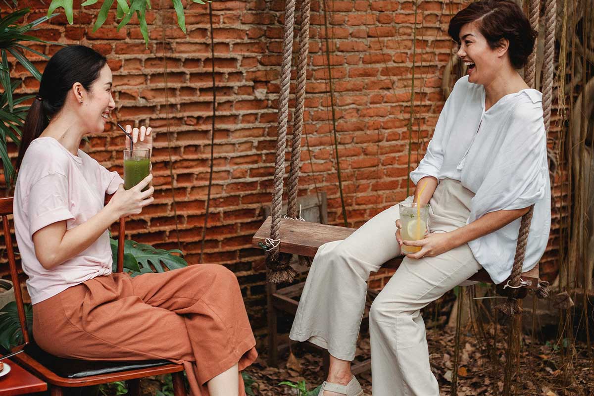 Two women drinking juice and talking