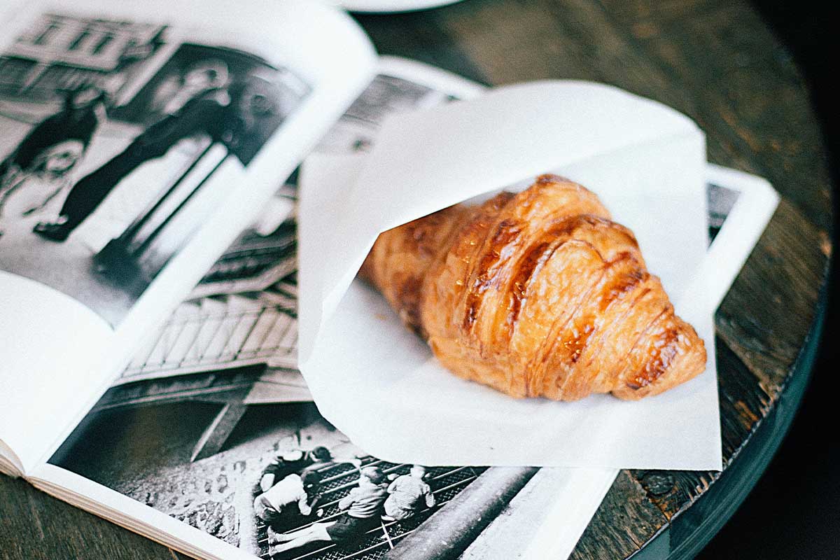 Croissant on a table with a magazine