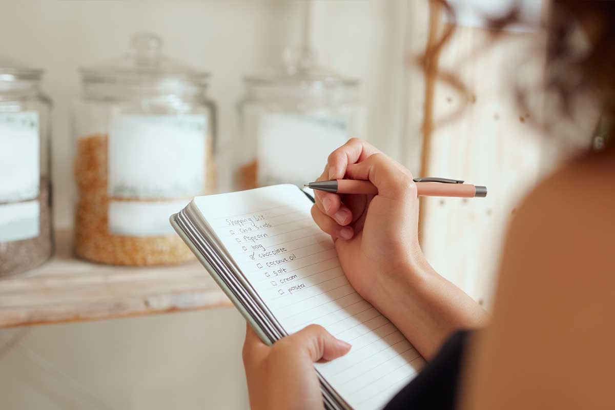 woman writing grocery/shopping list
