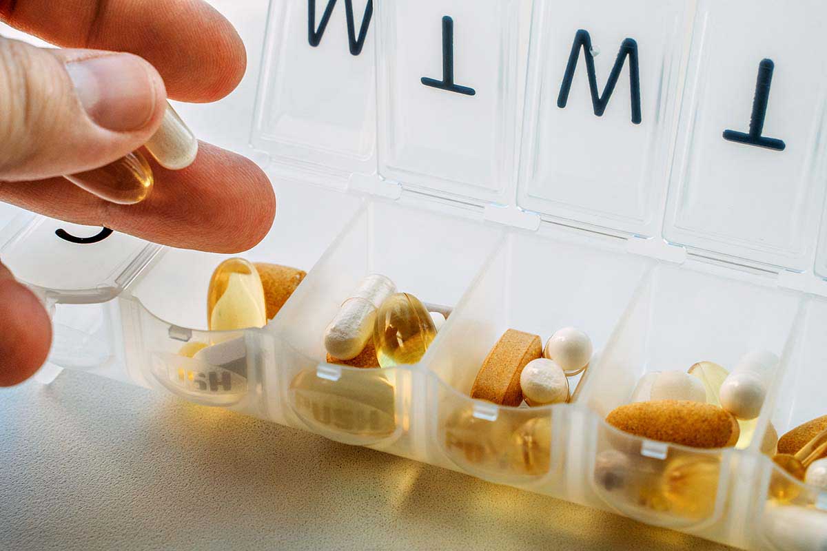 Person organizing a pill container
