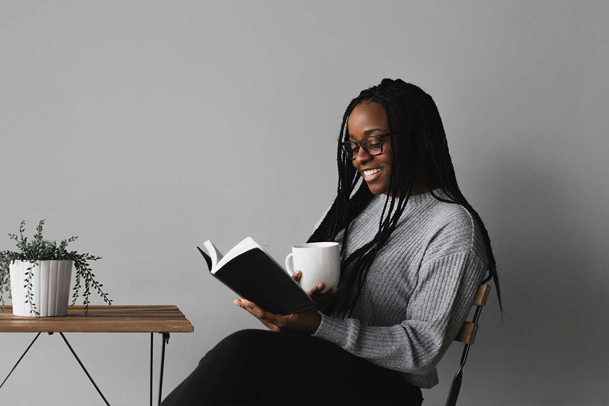 Woman reading a book with a cup of coffee